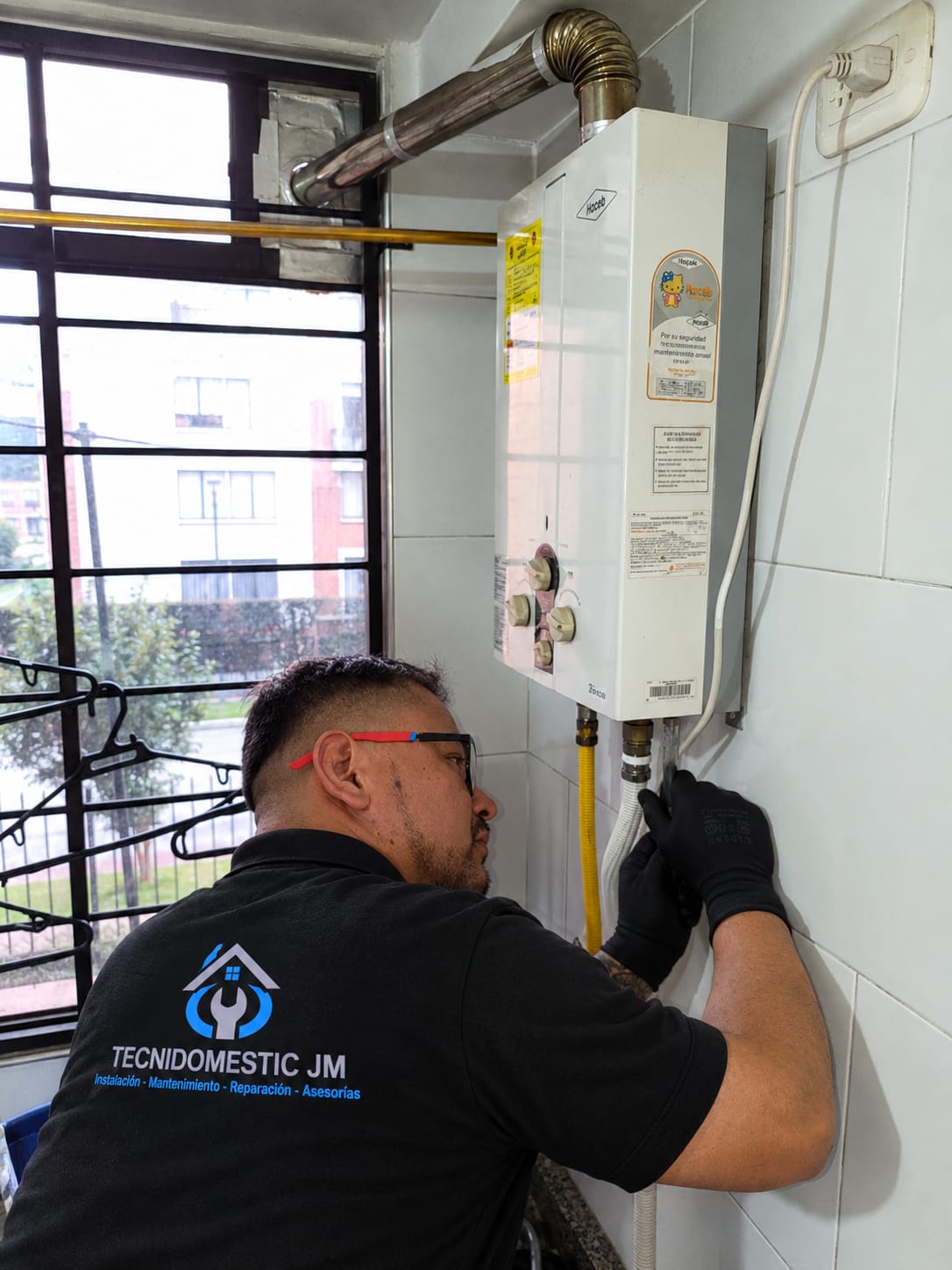 Técnico de Tecnidomestic JM realizando mantenimiento de calentador a gas en Bogotá
